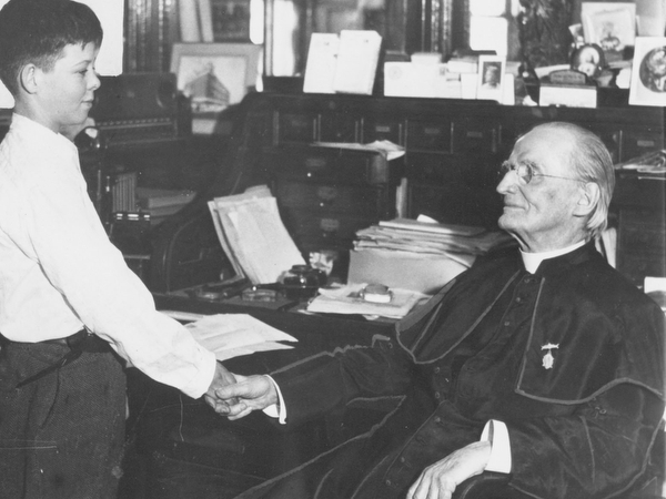 Father Baker shakes hands with one of the boys he helped through the Boys Home.